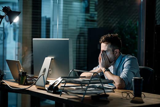 Fatigue man in shirt rubbing face while watching computer totally exhausted working late at night.